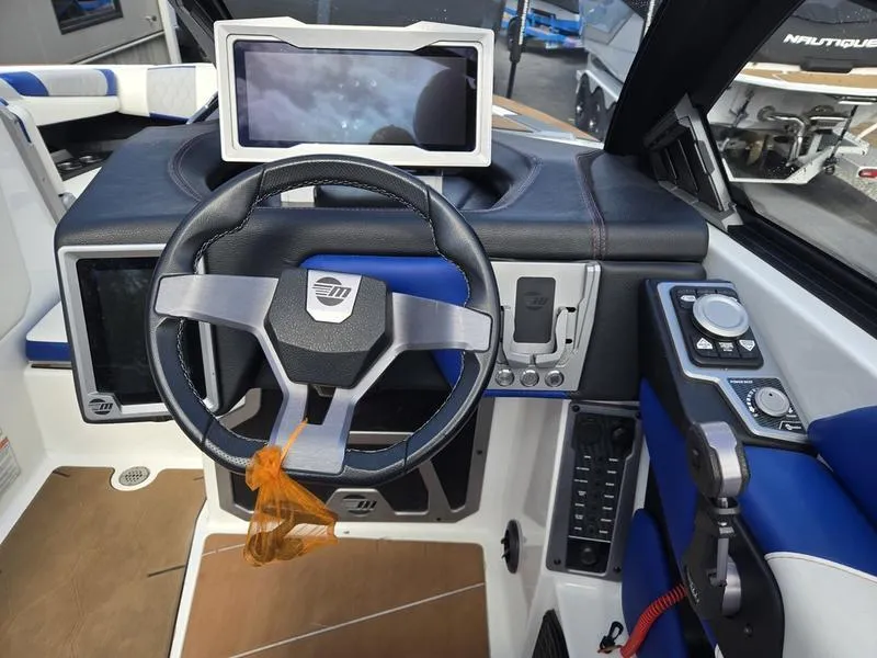 Slide: The Image of 2020 Malibu M240 boat dashboard with steering wheel and touchscreen display. - 23