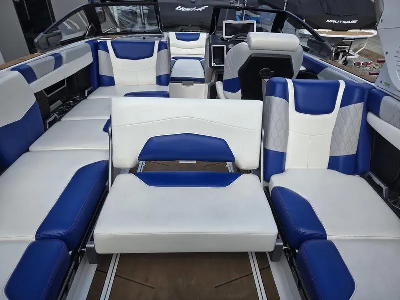 Slide: The Image of 2020 Malibu M240 boat interior with blue and white seating arrangement. - 25
