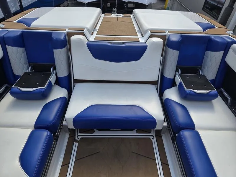 Slide: The Image of 2020 Malibu M240 boat interior with blue and white seating, featuring cup holders and modern design. - 28