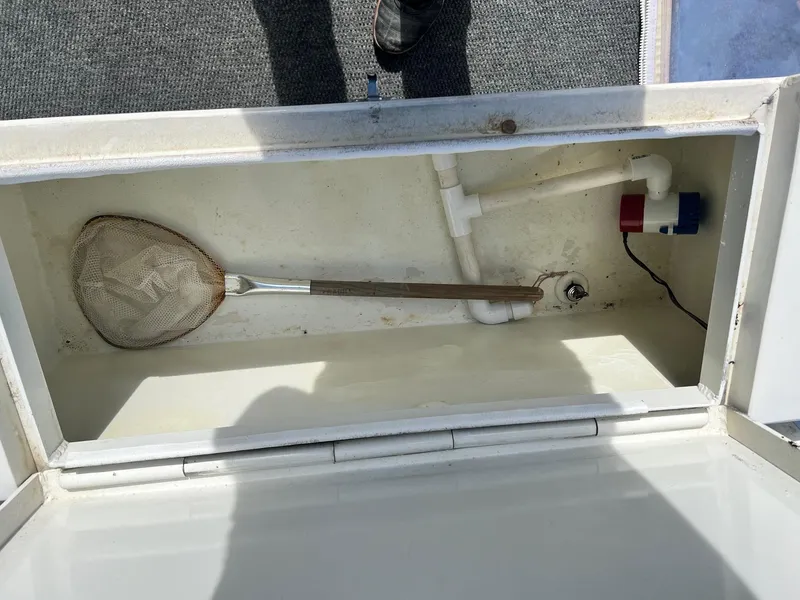 Slide: The Image of Open storage compartment in 1993 Gravois 23 DC boat with net and plumbing. - 10