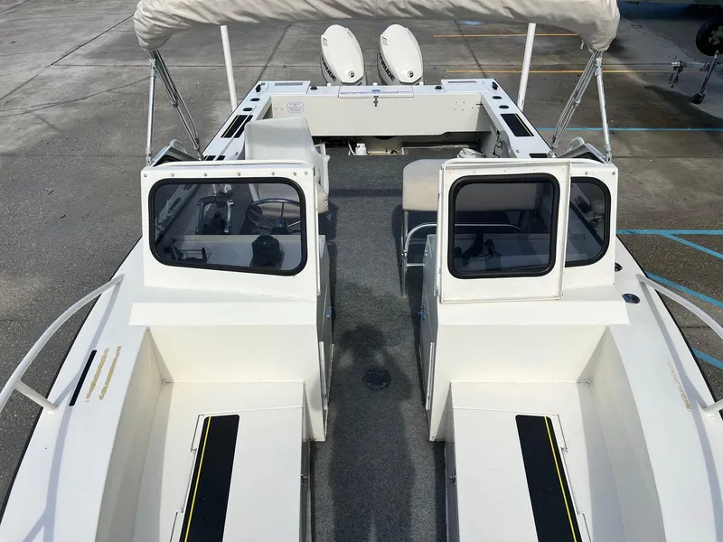 Slide: The Image of 1993 Gravois 23 DC boat with dual consoles and seating, docked on concrete surface. - 6