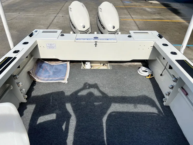 Slide: The Image of 1993 Gravois 23 DC boat interior with dual Evinrude engines, carpeted deck, and storage compartments. - 9
