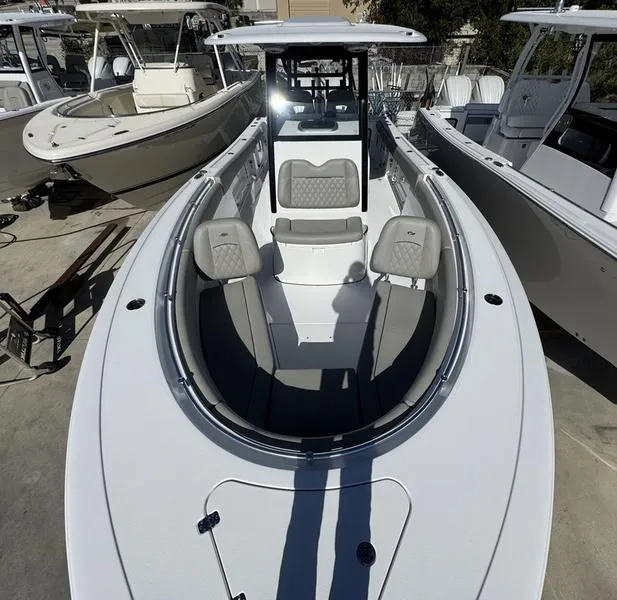 Slide: The Image of 2025 Sportsman Open 282 boat, sleek design, spacious seating, docked among other boats. - 13
