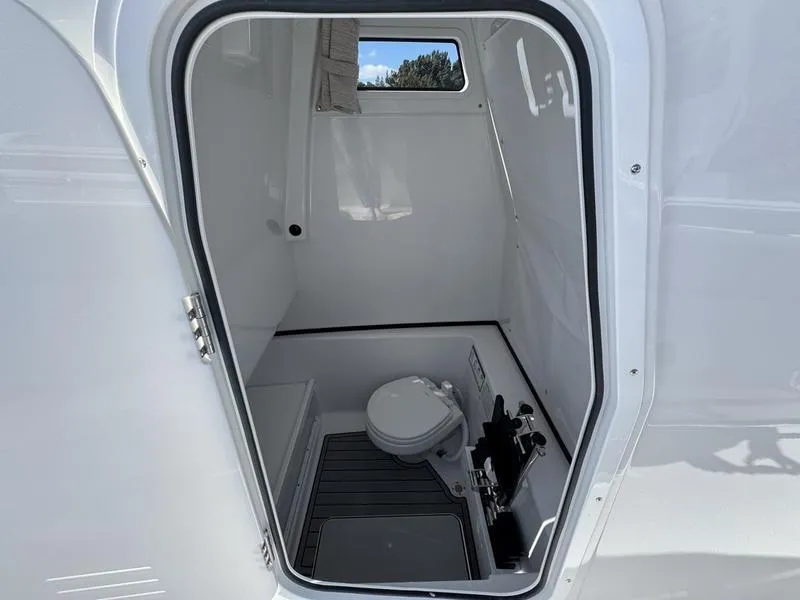 Slide: The Image of 2025 Sportsman Open 282 boat interior with compact marine toilet. - 22