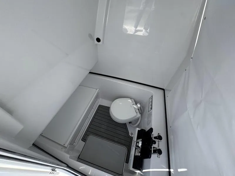 Slide: The Image of Interior of 2025 Sportsman Open 282 boat bathroom with toilet and sink. - 23