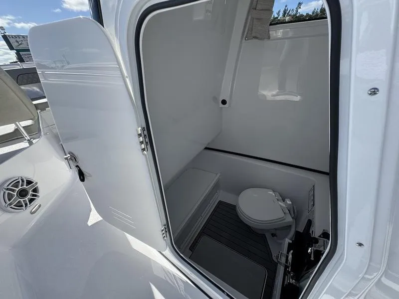 Slide: The Image of 2025 Sportsman Open 282 boat interior with compact marine toilet. - 24