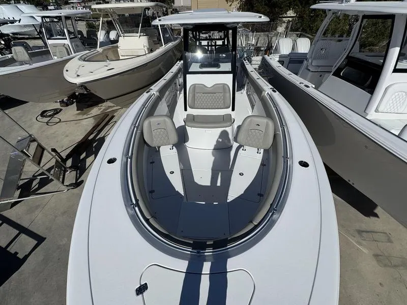 Slide: The Image of 2025 Sportsman Open 282 boat, sleek design, spacious deck, docked among other boats. - 5