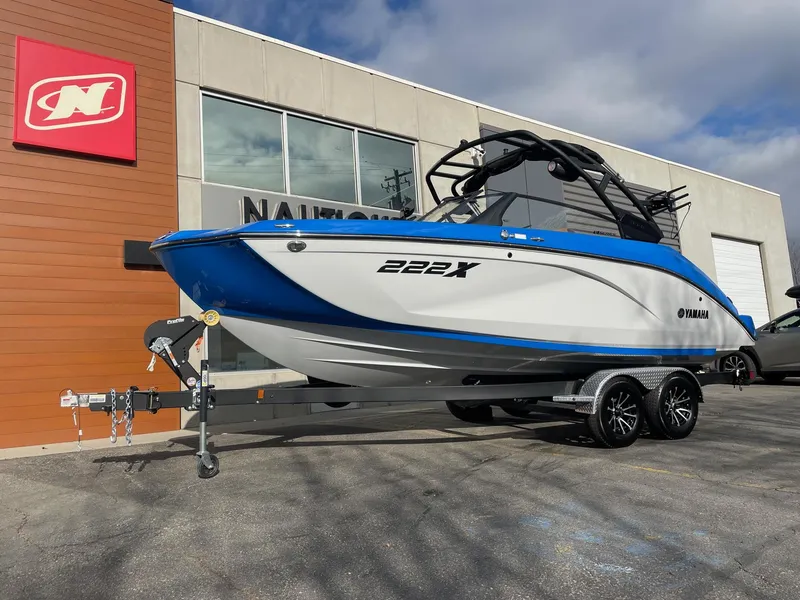 Slide: The Image of 2025 Yamaha Boats 222XE on trailer outside dealership. - 2
