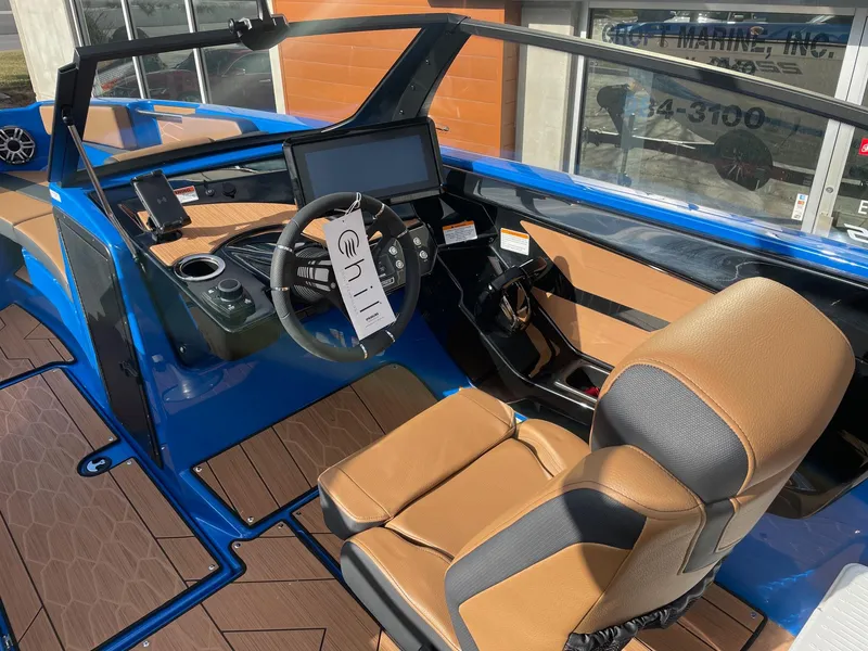 Slide: The Image of 2025 Yamaha Boats 222XE interior with modern dashboard and tan seating. - 5