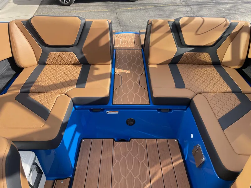 Slide: The Image of 2025 Yamaha Boats 222XE interior with tan and black seating, blue accents, and wood-style flooring. - 7