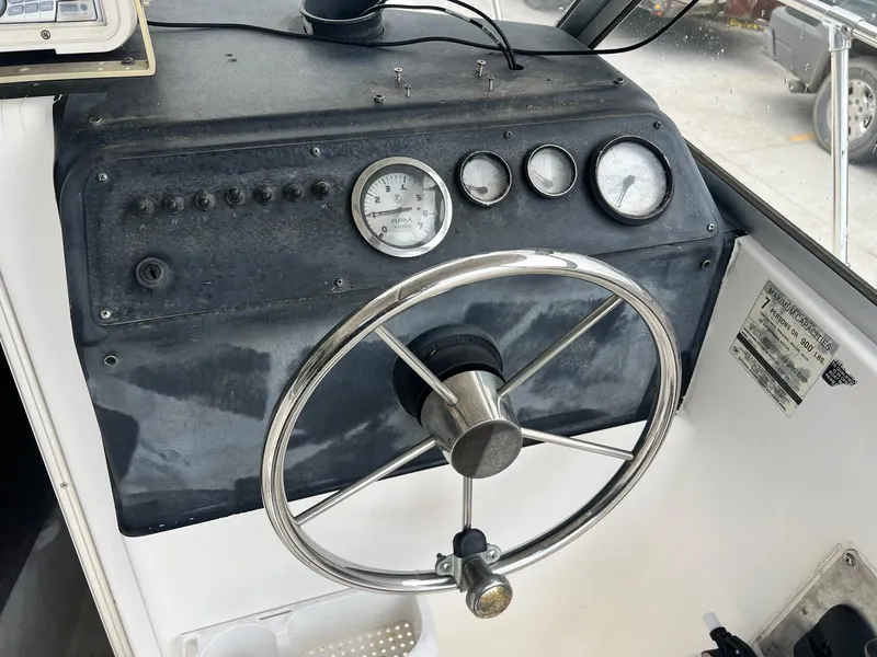 Slide: The Image of 1997 Bayliner 1802 FJ boat interior with Mercury 150 engine, featuring seating and rod holders. - 5