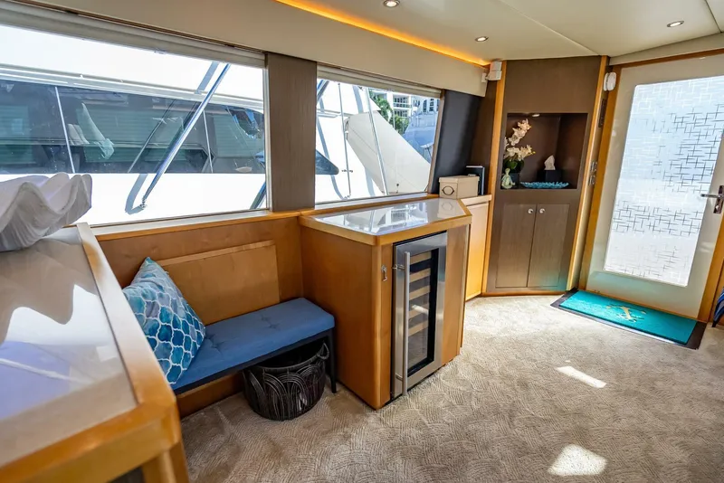 Slide: The Image of Interior of 1989 Hatteras 65 Enclosed Bridge yacht with seating and mini fridge. - 14