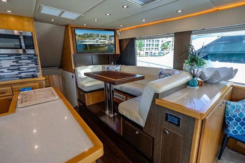 Slide: The Image of Luxurious interior of 1989 Hatteras 65 Enclosed Bridge yacht with modern seating and decor. - 17