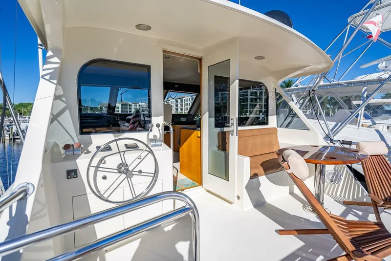 Slide: The Image of 1989 Hatteras 65 Enclosed Bridge yacht deck with seating and helm. - 20