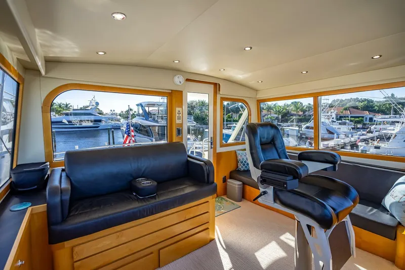 Slide: The Image of Interior of 1989 Hatteras 65 Enclosed Bridge yacht with leather seating and marina view. - 24