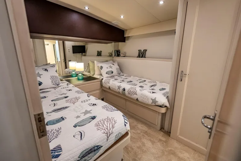 Slide: The Image of Cozy twin bedroom on 1989 Hatteras 65 Enclosed Bridge yacht with nautical-themed bedding. - 29