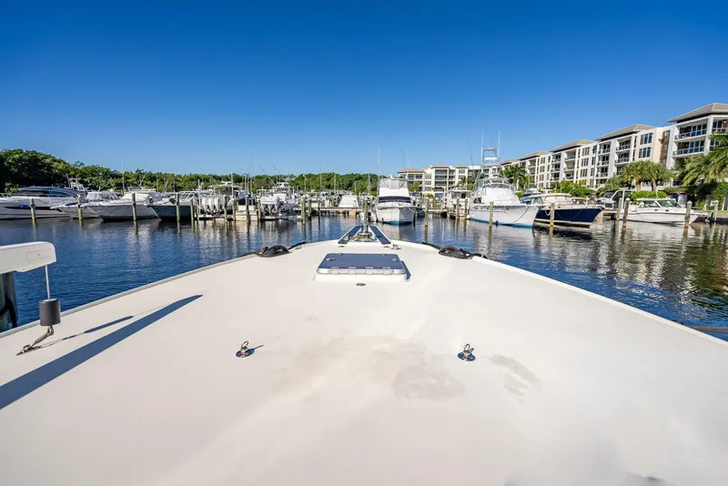 Slide: The Image of 1989 Hatteras 65 Enclosed Bridge yacht docked in a marina under clear blue skies. - 36