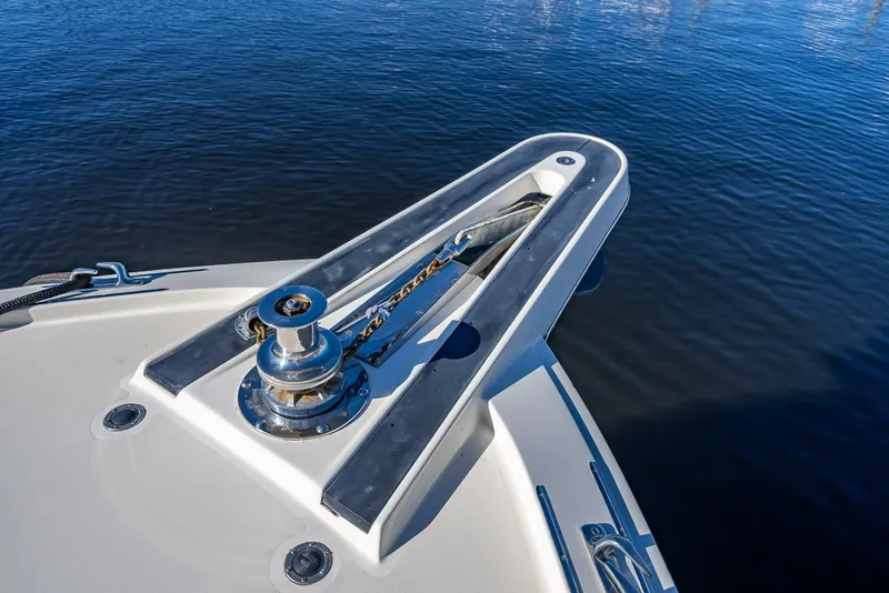 Slide: The Image of Bow of 1989 Hatteras 65 Enclosed Bridge yacht with anchor winch on calm water. - 37