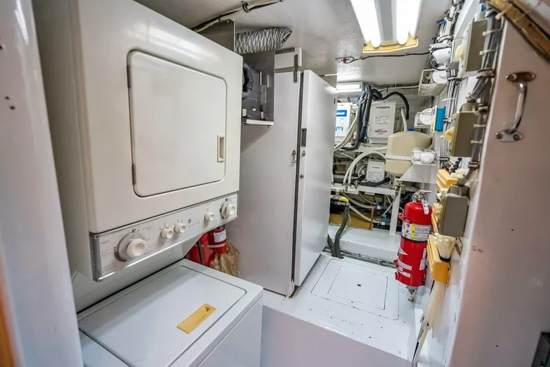 Slide: The Image of Laundry area in 1989 Hatteras 65 Enclosed Bridge yacht with washer, dryer, and fire extinguisher. - 38
