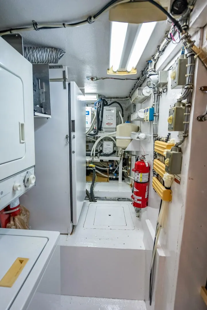 Slide: The Image of Engine room of 1989 Hatteras 65 Enclosed Bridge yacht with equipment and fire extinguisher. - 39
