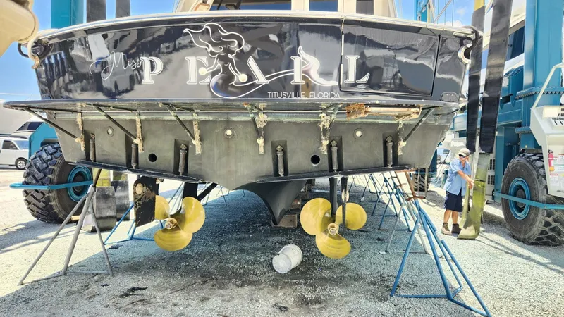Slide: The Image of 1989 Hatteras 65 Enclosed Bridge yacht on dry dock, showcasing propellers and hull. - 41