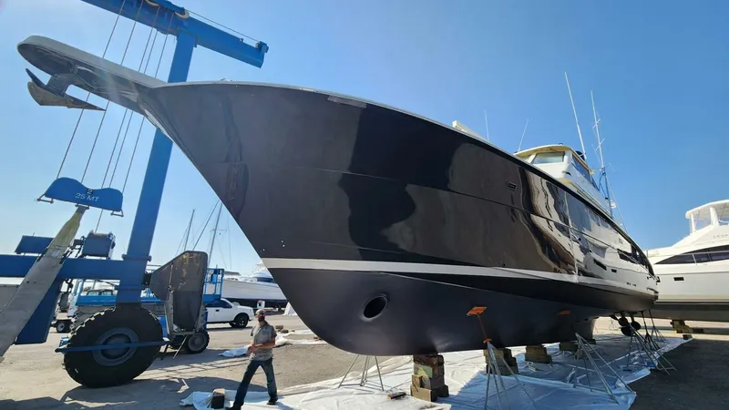 Slide: The Image of 1989 Hatteras 65 Enclosed Bridge yacht on dry dock under clear blue sky. - 42