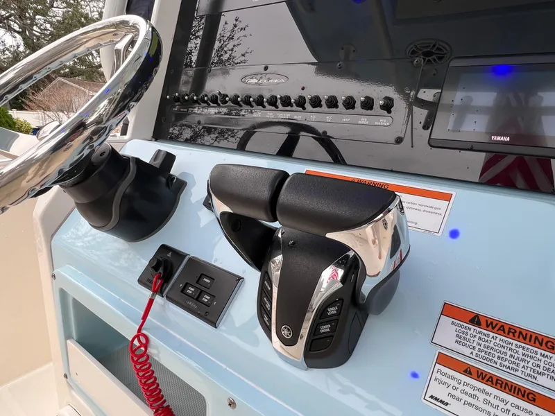 Slide: The Image of 2023 Cobia 280 Center Console helm with steering wheel and throttle controls. - 10