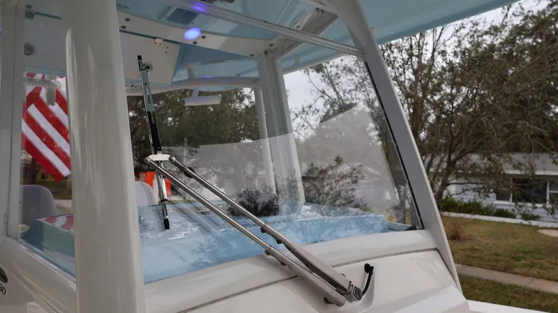 Slide: The Image of 2023 Cobia 280 Center Console boat windshield with wiper, American flag in background. - 13