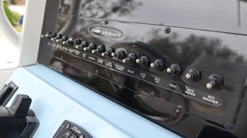 Slide: The Image of Control panel of 2023 Cobia 280 Center Console boat with switches and labels. - 16