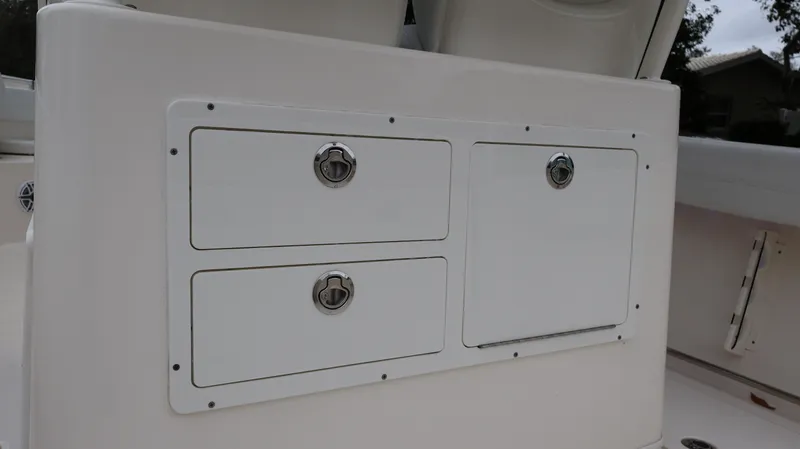 Slide: The Image of 2023 Cobia 280 Center Console storage compartments with secure latches. - 23