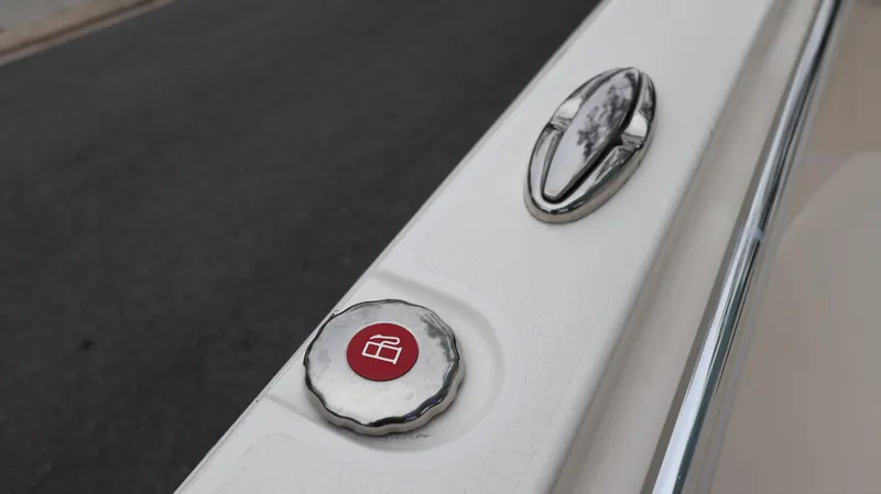 Slide: The Image of Close-up of 2023 Cobia 280 Center Console boat detail with red button and chrome handle. - 33