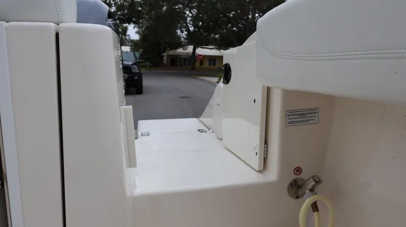 Slide: The Image of 2023 Cobia 280 Center Console boat interior detail, featuring storage compartment and seating. - 35