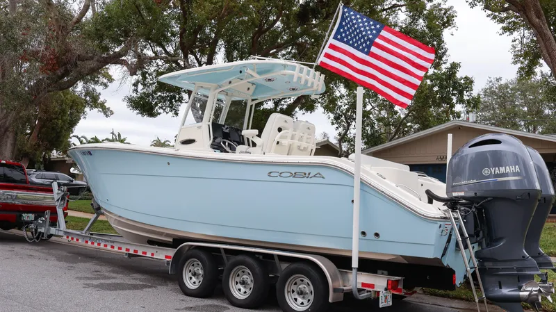 Slide: The Image of 2023 Cobia 280 Center Console boat on trailer with American flag and Yamaha engine. - 4