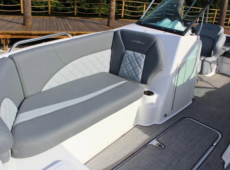 Slide: The Image of 2024 NauticStar DC Deck boat interior with gray and white seating. - 11