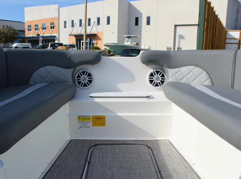 Slide: The Image of 2024 NauticStar DC Deck boat interior with gray seating and speakers. - 25