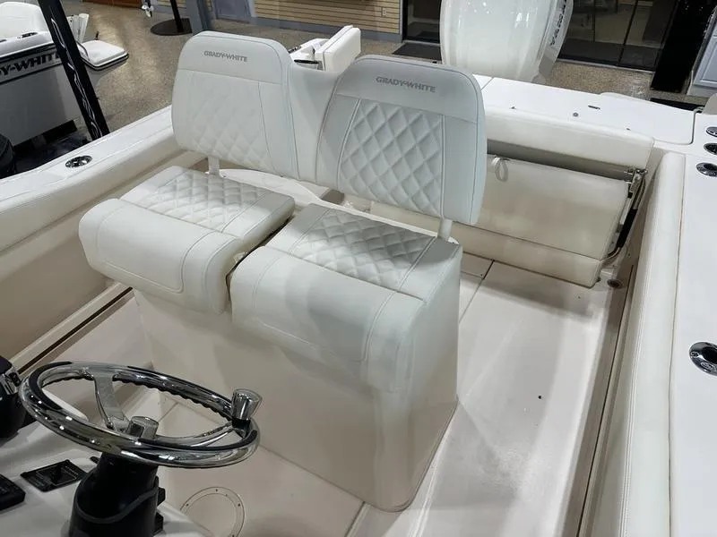 Slide: The Image of 2025 Grady-White Fisherman 236 boat interior with white cushioned seating and steering wheel. - 9