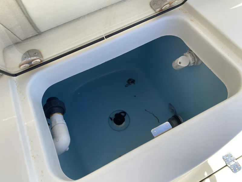 Slide: The Image of Open livewell compartment in 2013 ShearWater 25LTZ boat, showing plumbing and fittings. - 12