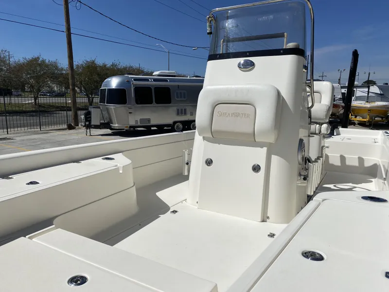 Slide: The Image of 2013 ShearWater 25LTZ boat interior with console, parked near an Airstream trailer. - 19