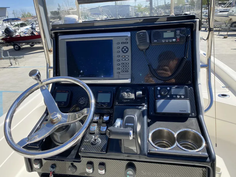 Slide: The Image of 2013 ShearWater 25LTZ boat dashboard with steering wheel, Garmin display, and Yamaha controls. - 8