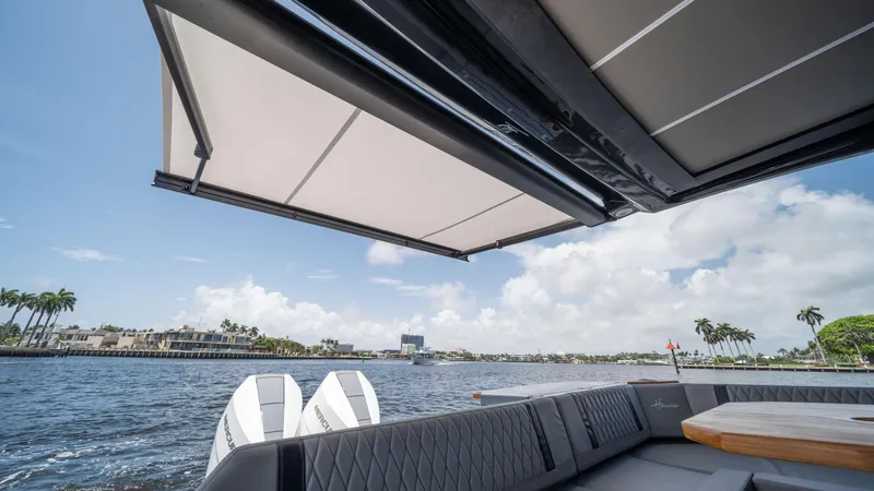 Slide: The Image of Luxury seating on 2025 Hanover 387 Outboard boat with scenic waterfront view. - 22