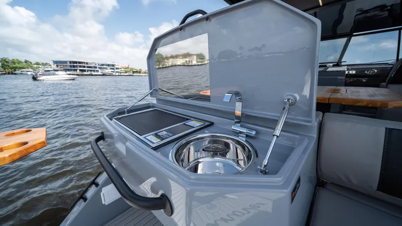 Slide: The Image of 2025 Hanover 387 Outboard boat with onboard kitchenette and sink by the water. - 25