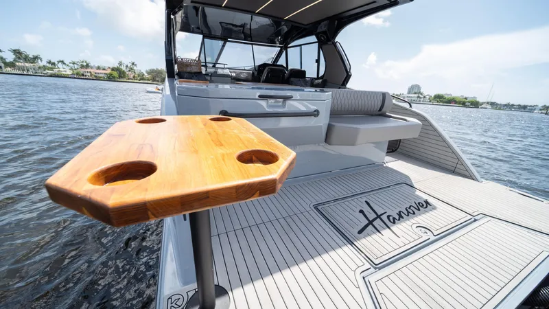 Slide: The Image of 2025 Hanover 387 Outboard boat with wooden table on deck, scenic water view. - 27