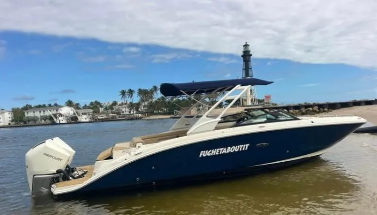 Slide: The Image of 2022 Sea Ray SDX 290 Outboard boat near lighthouse, blue and white design. - 1