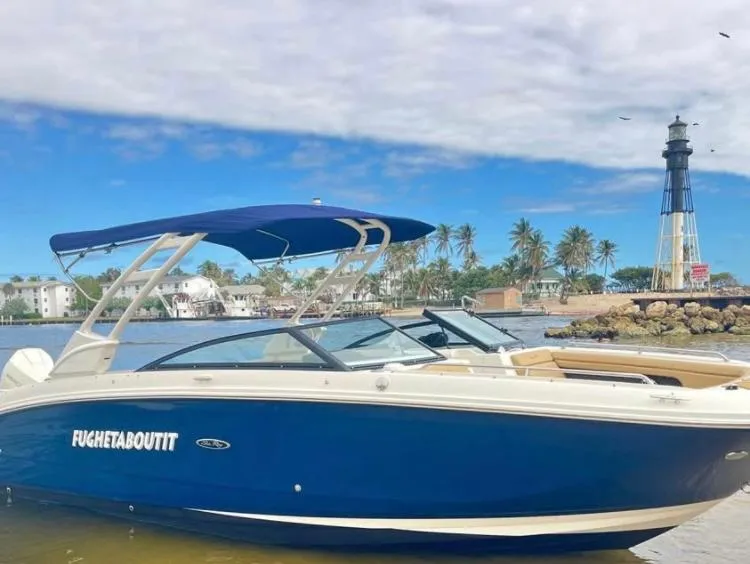 Slide: The Image of 2022 Sea Ray SDX 290 Outboard boat near a lighthouse and palm trees. - 2