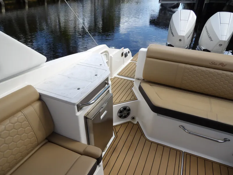 Slide: The Image of 2022 Sea Ray SDX 290 Outboard interior with tan seating and teak flooring. - 26