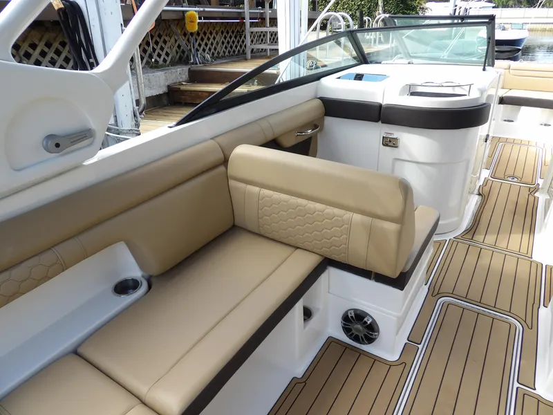 Slide: The Image of 2022 Sea Ray SDX 290 Outboard interior with tan seating and wood-style flooring. - 30