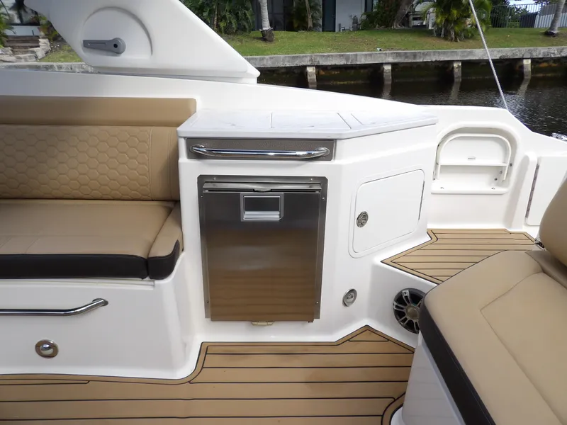 Slide: The Image of 2022 Sea Ray SDX 290 Outboard interior with tan seating and sleek cabinetry. - 31