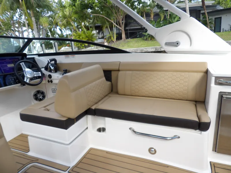Slide: The Image of 2022 Sea Ray SDX 290 Outboard interior with beige seating and modern dashboard. - 35