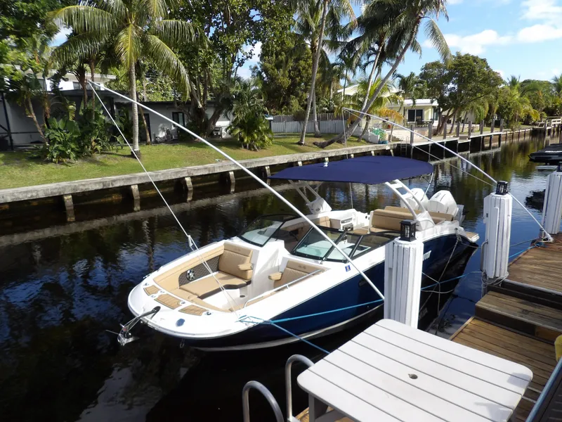 Slide: The Image of 2022 Sea Ray SDX 290 Outboard docked by a canal with lush greenery. - 4