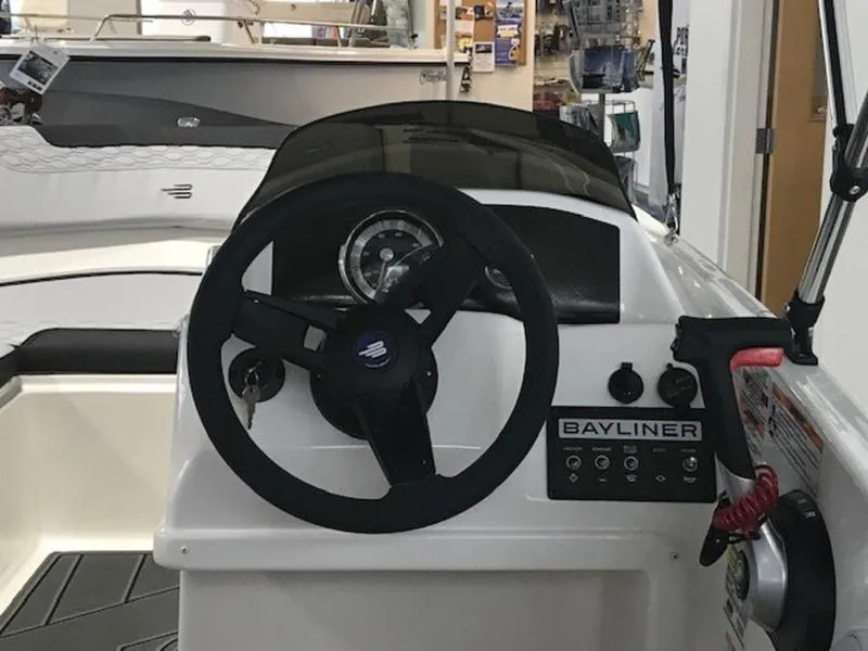 Slide: The Image of 2025 Bayliner M15 boat dashboard with steering wheel and control panel. - 12